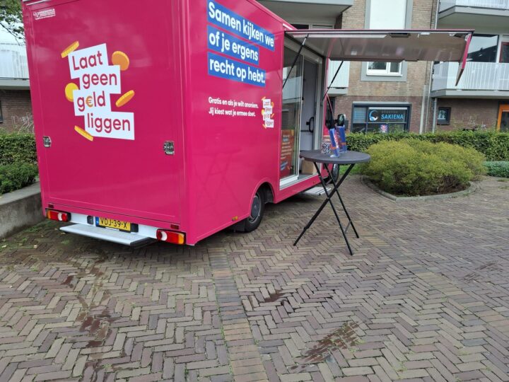 De roze Geldcamper van de campagne Laat geen geld liggen staat met open luifel voor het pand van Stichting Sakiena aan de Jan Evertsenlaan in Voorschoten